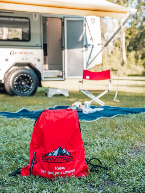 SAVITREK brand, Large, black, waterproof, wind proof, australian made picnic rug and safety hi vix blanket with caravan in background