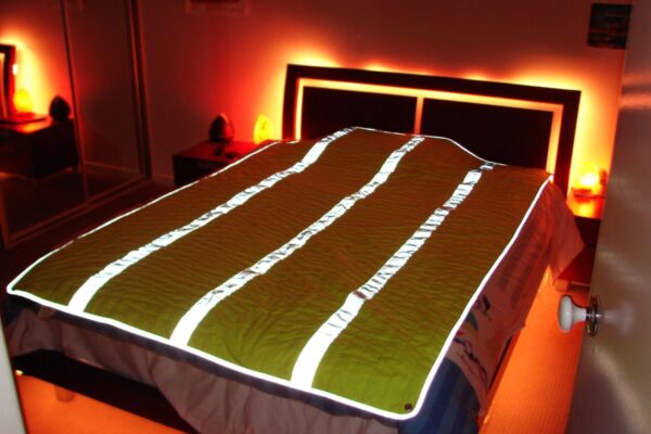 A SAVITREK hi viz blanket being used on a bed